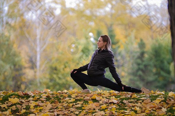 女孩体操运动员伸展运动腿秋天公园一边角