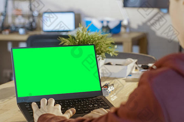 聪明男孩在他的计算机科学课上使用带有模拟绿色屏幕的笔记本电脑。
