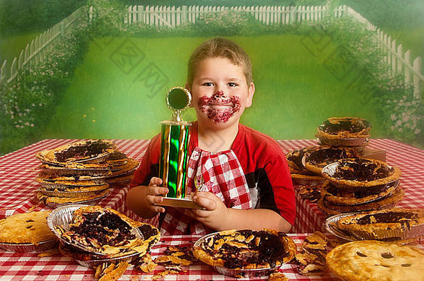 胖乎乎的男孩结束馅饼吃比赛赢得金牌