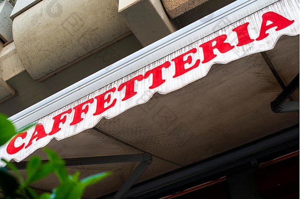 文本caffetteria在遮阳帘上。意大利咖啡馆。咖啡厅的正面。咖啡馆和糖果店前的绿叶。