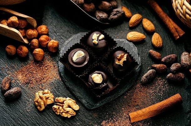 黑石公司制作的心形手工巧克力糖果，装在糖果包装内。顶部有坚果的巧克力糖果、可可豆、肉桂