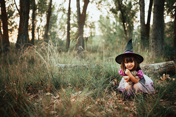 万圣节期间，在树林里扮成女巫的微笑女孩
