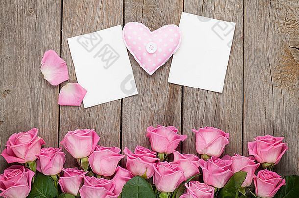 粉红色的玫瑰手工制作玩具心情人节一天空白问候卡片照片帧木表格前视图复制