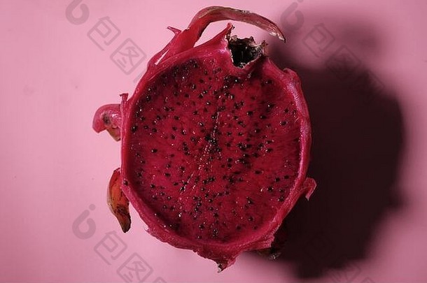 粉红色背景上的新鲜有机龙果，创意夏季食品概念。
