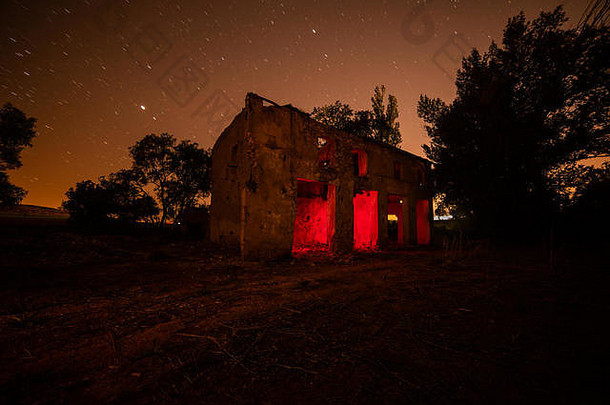 摄影长曝光被遗弃的房子照亮内部红色的颜色