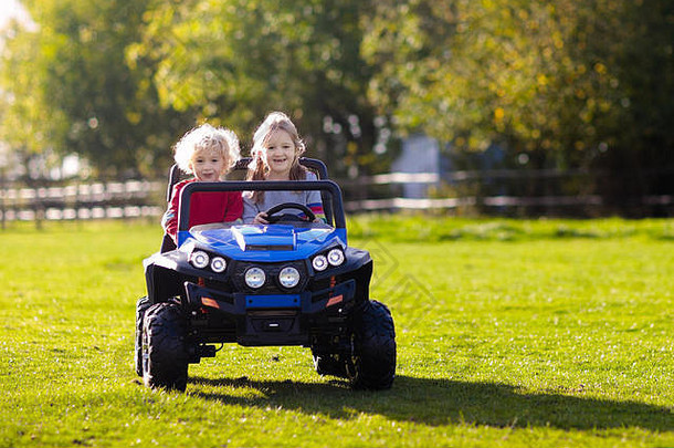 孩子们在夏季公园驾驶<strong>电动玩具</strong>车。户外<strong>玩具</strong>。<strong>电动</strong>汽车中的儿童。小男孩和小女孩在花园里骑<strong>玩具</strong>卡车。家庭