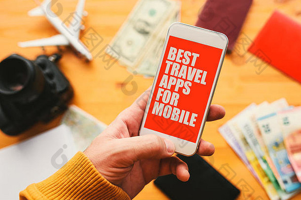 手机最佳旅行应用。男子手持智能手机，模拟应用程序屏幕与假日旅行相关。