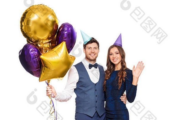 戴着派对帽和气球的幸福夫妇