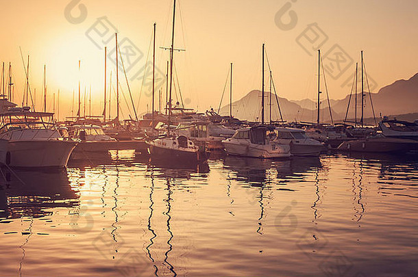 在夕阳的余晖中，游艇停泊在海湾里