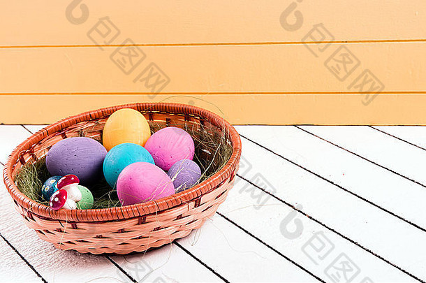 木制背景上篮子里的彩色复活节彩蛋。无暴力侵害动物的环保材料