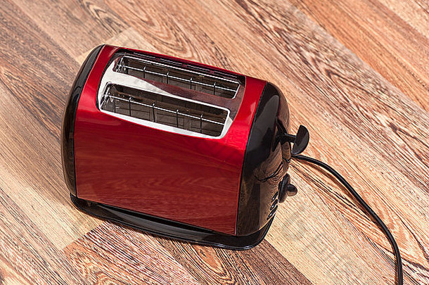 木制背景上的红色烤面包机