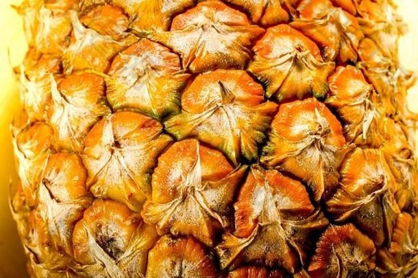 新鲜菠萝皮和果肉的宏观照片。外来水果的抽象背景。
