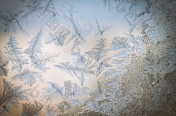 冬季梦幻世界主题概念：彩色光霜窗玻璃自然冰纹宏观图像