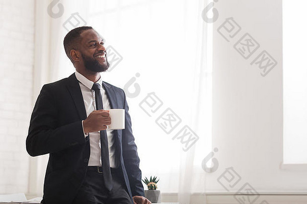 英俊开朗的非洲商人在窗边喝咖啡