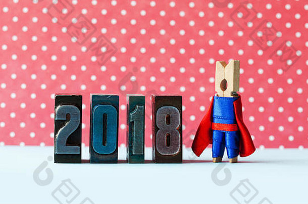 超级灵感2018新年贺卡。创意超级英雄领袖在复古版印刷数字附近摆姿势。穿红蓝色服装的隐喻角色。红色圆点背景