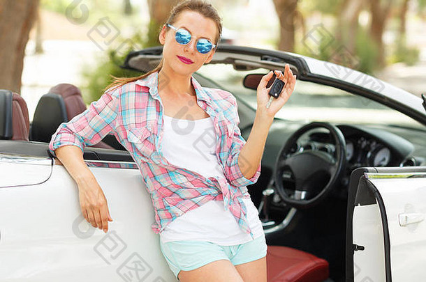 手持钥匙站在敞篷车附近的年轻美女——购买<strong>二手车</strong>或租车的概念