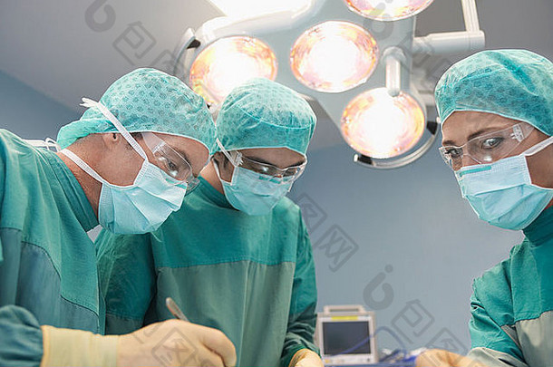 三名<strong>外科</strong>医生工作时手术室的低角度视图