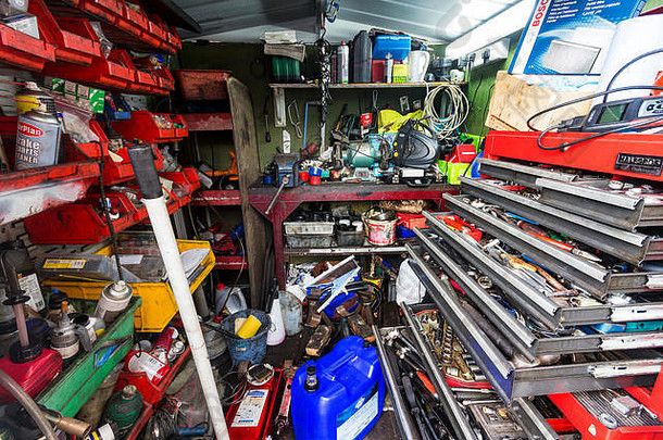 非常小的机械车间，有各种工具、设备和消耗品，展示了一个杂乱但繁忙的专业工作区供探索。