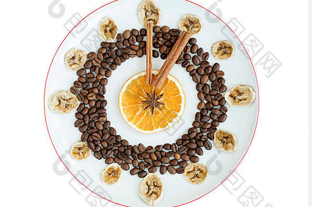 烤咖啡粒、干橙子和香蕉杯、肉桂棒、八角星以碗中时钟的形式躺在瓷盘上