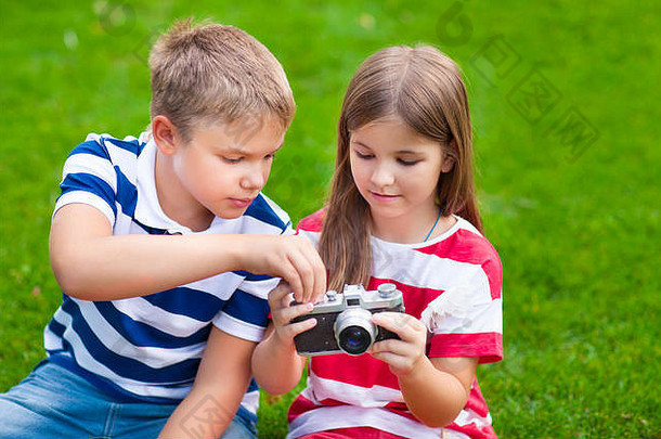 年轻的摄影师漂亮的哥哥妹妹玩相机夏天公园