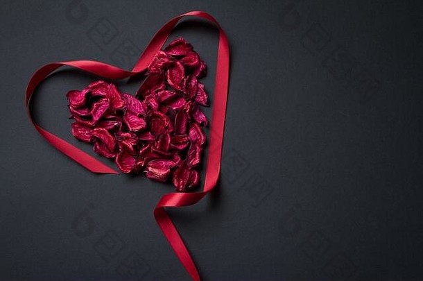 红色的花瓣和黑色背景上心形的丝带，恭喜你