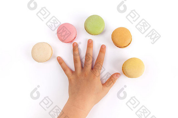 孩子的手在白色背景上用五颜六色的麦卡龙张开手指