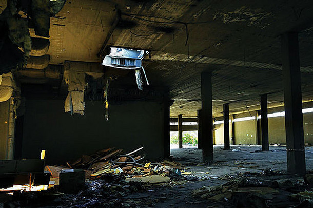废弃的工厂内部破旧的绝缘材料悬挂在天花板上。
