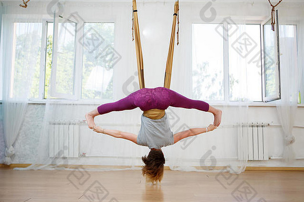 年轻女子在吊床上练习空中瑜伽