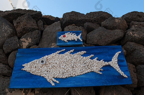 西班牙北非加那利群岛富尔特文图埃岛埃尔科蒂略：手工制作的装饰品，<strong>黑色岩石</strong>上挂着鱼的木板