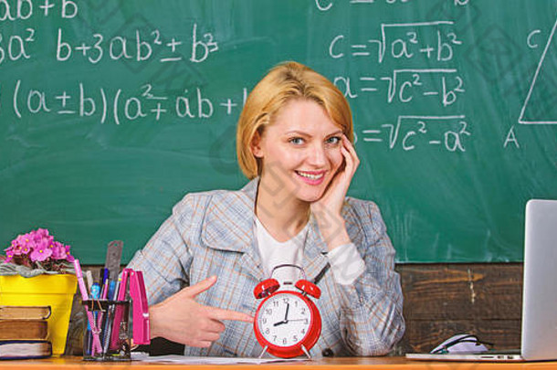 老师把闹钟放在黑板上。时间学习和教育。现代学校。知识日。教室里的女人。学校在家教育。快乐的女人。回到学校。<strong>教师节</strong>。我没有时间。