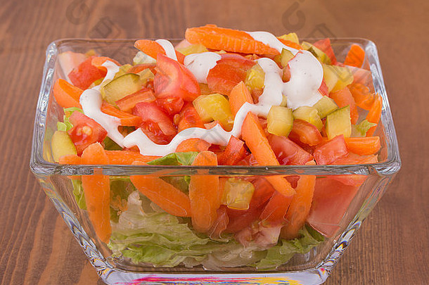 开胃沙拉配生菜、西红柿、胡萝卜和泡菜，配调味品，放在深色木桌上