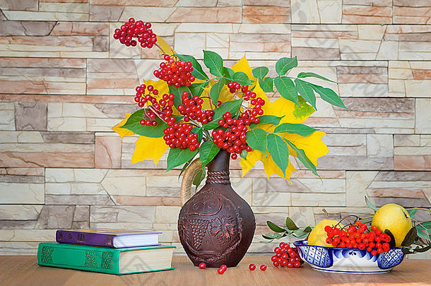 秋天黄色的叶子明亮的红色的浆果陶瓷壶罗文浆果秋天生活