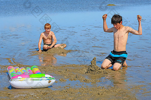 德国石勒苏益格-荷尔斯泰因州圣彼得奥丁海滩，两个男孩在沙滩上玩耍
