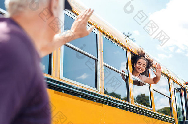父亲挥舞着女儿学校公共汽车微笑快乐的