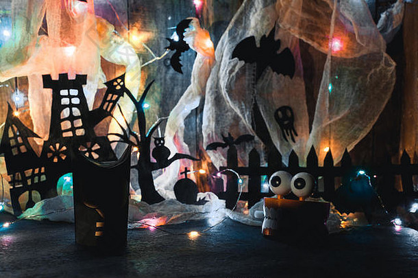 巫婆们的房子里有一棵用黑纸刻成的阴森恐怖的树，旁边是猫头鹰和爪子，墙上挂着蜘蛛网和LED花环。