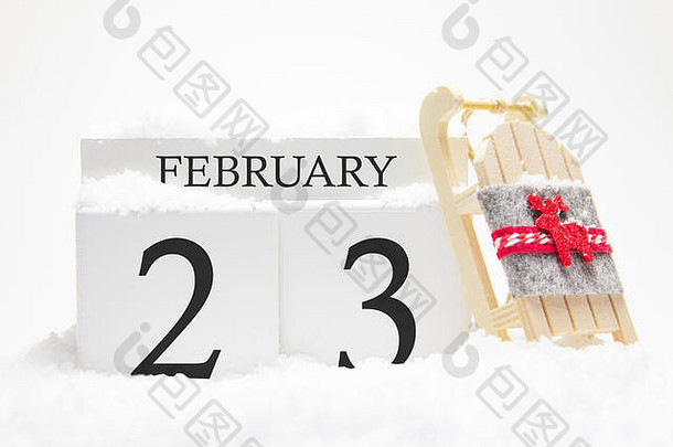 二月的木制日历，冬季月份的第23天。冬天的象征是雪和雪橇。假期、假期和冬季乐趣的概念。