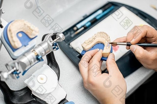 牙科技术员着色牙科假肢油漆刷实验室特写镜头视图概念植入 物生产
