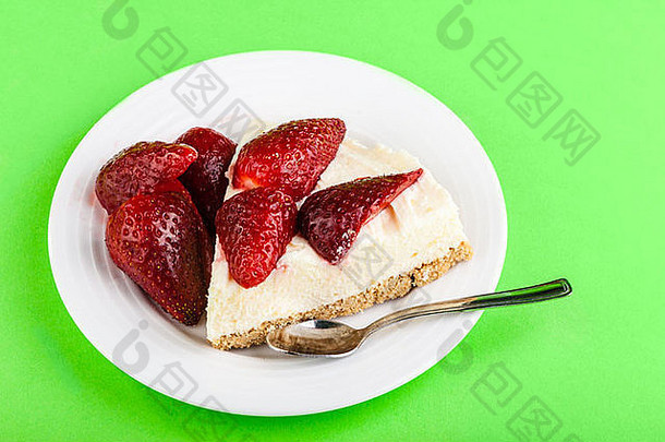 一块美味的草莓芝士蛋糕，白色盘子，绿色背景