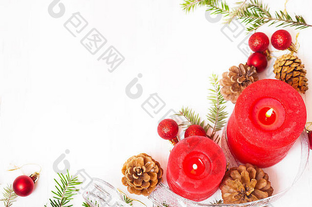 白色背景上的红蜡烛、冷杉枝和圣诞装饰品