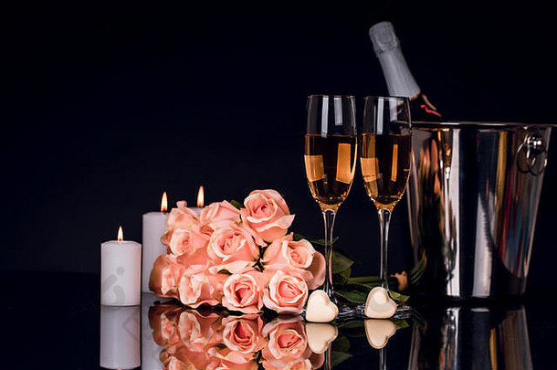 香槟瓶桶酒眼镜花束玫瑰心形状的巧克力蜡烛黑色的背景爱情人节一天