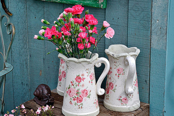 花园棚屋的陶瓷壶和粉色康乃馨装饰生活方式安排