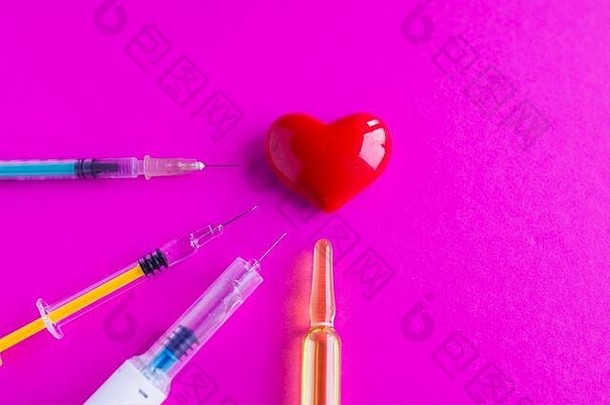 粉红色背景上带注射器的容量心脏。支持心脏病患者的理念