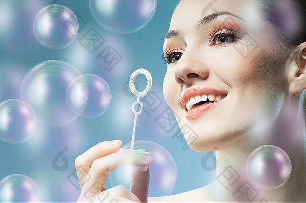 美年轻的女人吹肥皂泡沫