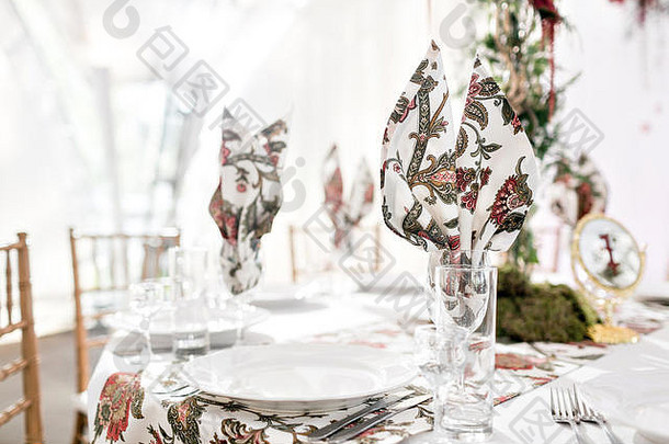 为宾客准备的婚礼帐篷内部装饰。在户外的圆形宴会桌上摆满了花和丝绸。餐饮理念
