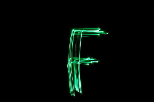 绿色灯光绘画摄影.黑色背景上字母系列的字母F。长曝光摄影，抽象绿色运动