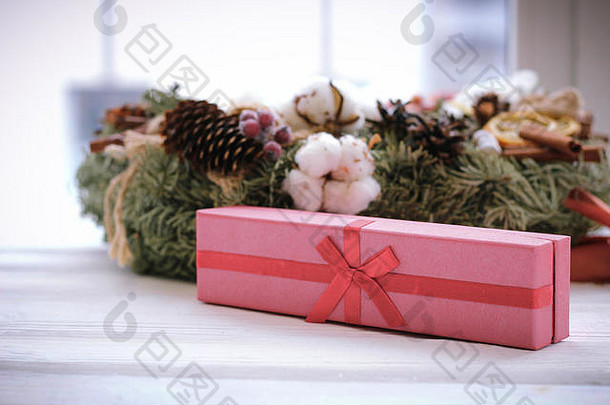 彩纸包装的礼品盒和白色的圣诞花圈