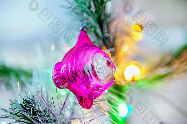圣诞树上挂着一条红色的鱼，是美丽的圣诞装饰品。圣诞节的家庭装饰。
