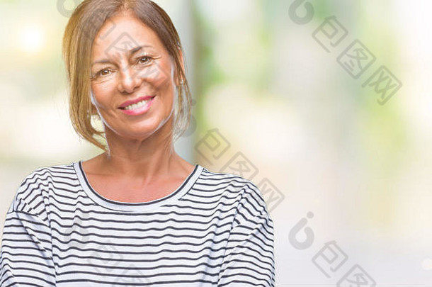中年拉美裔老年妇女在孤立的背景下微笑着双臂看着摄像机。积极的人。