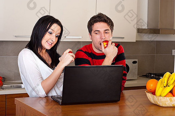 年轻的夫妇吃<strong>苹果</strong>移动PC厨房
