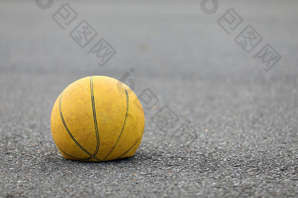 左手焦点累了放气黄色的篮球路surafce概念空气穿花了被丢弃的体育运动设备